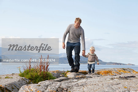 Man and son strolling by fjord, Aure, More og Romsdal, Norway