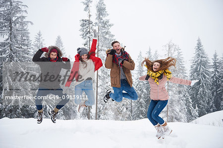 Friends jumping in snow