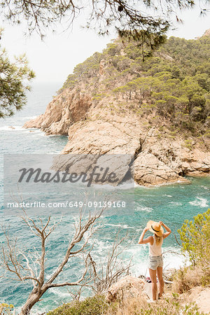 Woman along coastline, looking at view, elevated view, Tossa de mar, Catalonia, Spain