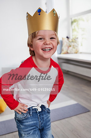 Portrait of young boy, wearing cardboard crown, smiling