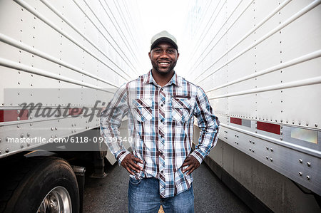 A truck driver with his truck parked in a lot at a truck stop.