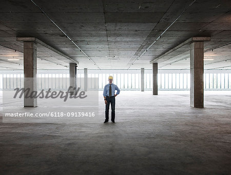 Asian businessman in a new empty raw office space.