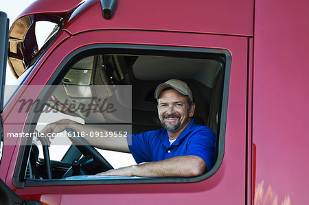 Portrait of a Caucasian man driver and his  commercial truck.