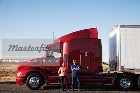 Portrait of a Caucasian husband and wife driving team with their  commercial truck.