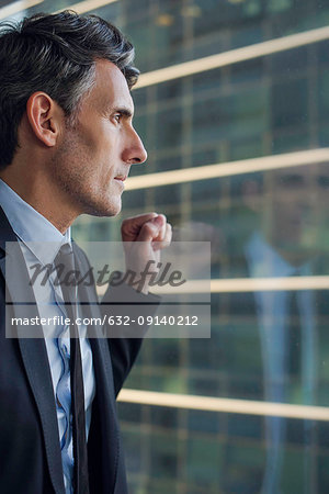Man looking through window in high rise building
