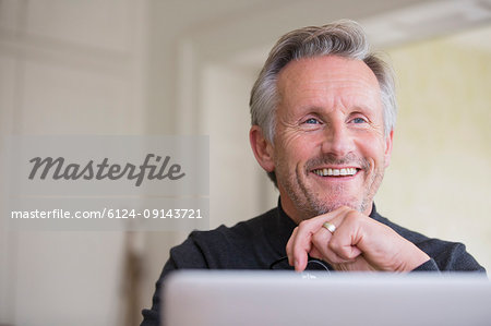 Smiling, confident male freelancer working at laptop