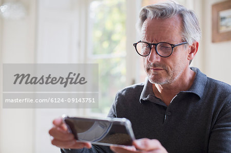Focused mature man using smart phone