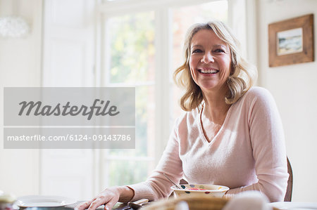 Smiling, confident mature woman eating