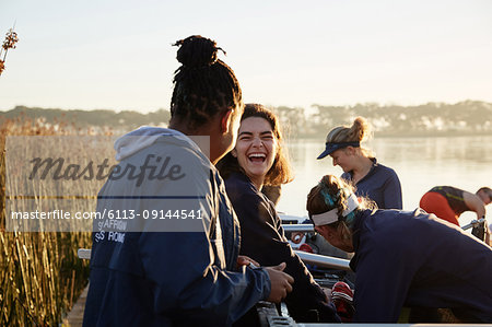Female rowers laughing at lakeside