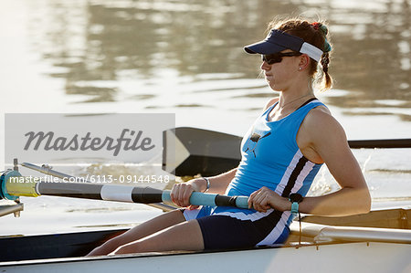 Determined female rower rowing scull