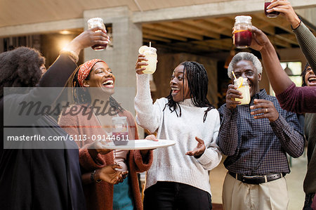 Enthusiastic multi-generation family toasting lemonade and sangria on patio