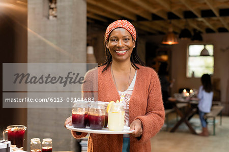 Portrait smiling, confident woman serving lemonade and sangria