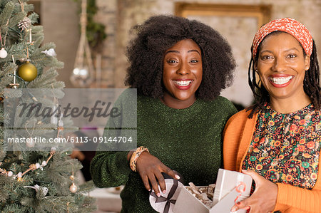 Portrait smiling, enthusiastic mother and daughter opening Christmas gift