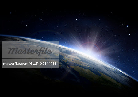 Sunlight ascending over Earth in outer space