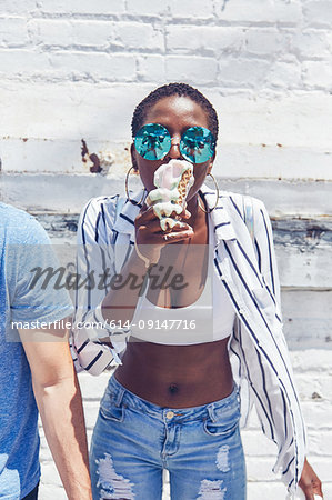 Young women eating melting ice cream cone