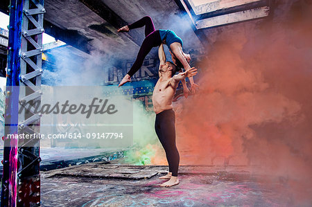 Couple practising acroyoga on outdoor stage