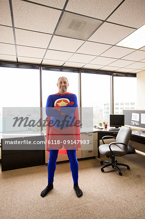 A self satisfied Caucasian office super hero in his cubicle office.