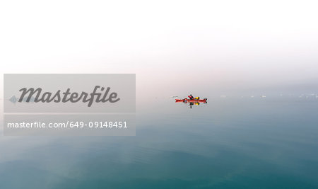 Person sea kayaking in mist, Narsaq, Kitaa, Greenland