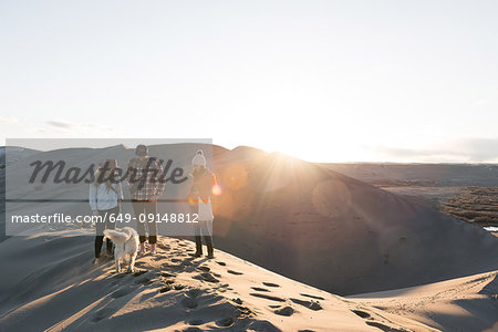 Friends with dog on sand dune, Bruneau, Idaho, USA