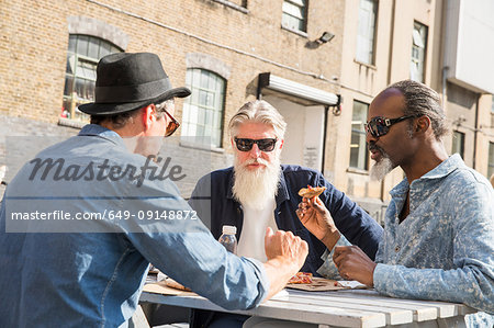 Friends having pizza outdoors, London, UK