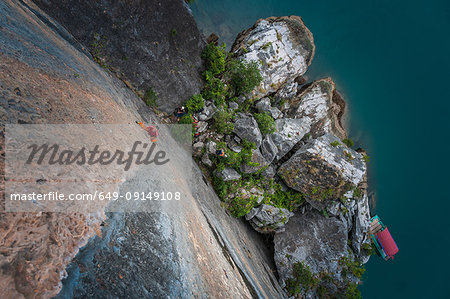 Man rock climbing on limestone rock, overhead view, Ha Long Bay, Vietnam