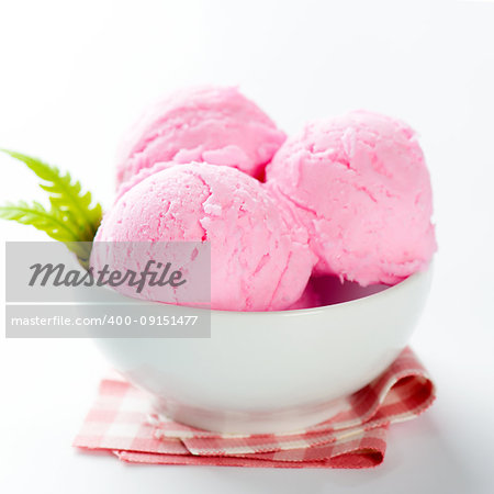 Pink ice cream in bowl on white background.