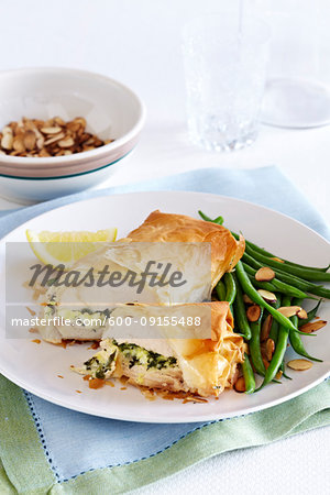 Stuffed chicken wrapped in phyllo pastry with almond green beans on the side