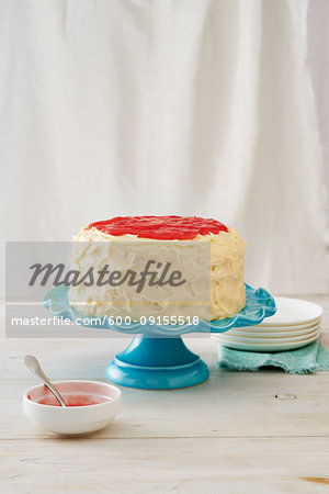 Vanilla rhubarb cake on a turquoise cake stand with white background