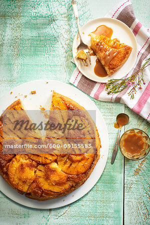 Grilled pineapple upside down cake with caramel sauce on a green background