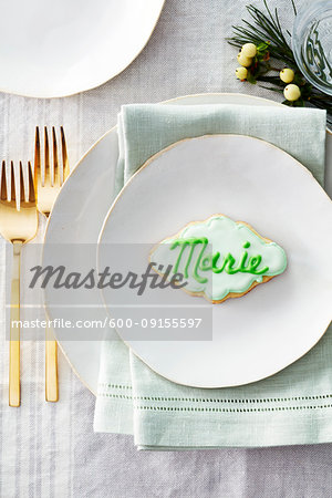 Sugar cookie place card with name in icing on a dinner plate in a festive place setting