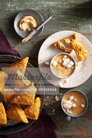 White hot chocolate with pumpkin scones and maple butter on a wooden background