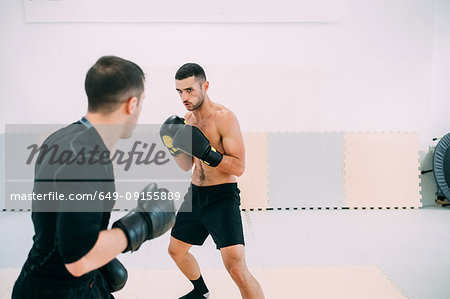 Men in gym sparring