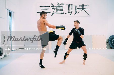 Men in gym kickboxing