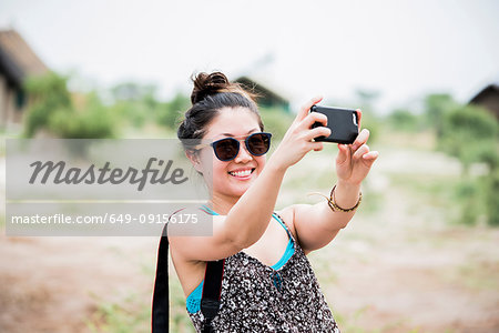 Young female tourist taking smartphone selfie, Botswana, Africa