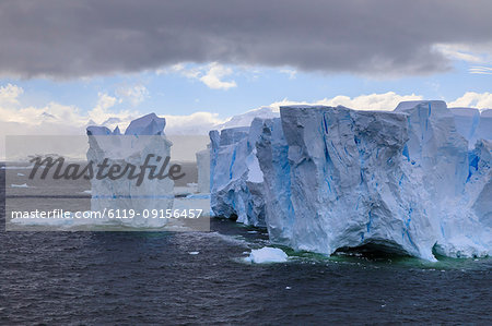 Large blue tabular iceberg and coast of Errera Channel, Danco Coast, Antarctic Peninsula, Antarctica, Polar Regions