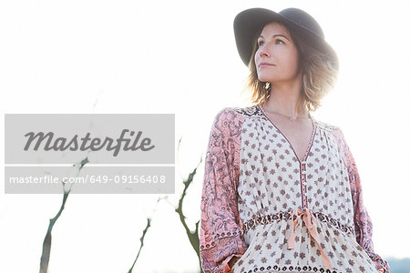 Mid adult woman wearing felt hat against sunlit sky