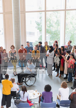 Audience clapping for male speaker in wheelchair