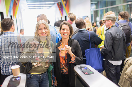 Portrait smiling, confident women showing lanyard conference passes