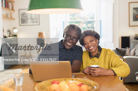 Portrait smiling, confident senior couple using laptop at dining table