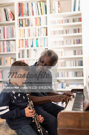 Grandfather and grandson playing piano and clarinet