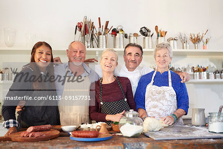 Portrait happy, confident senior friends and chef in pizza cooking class