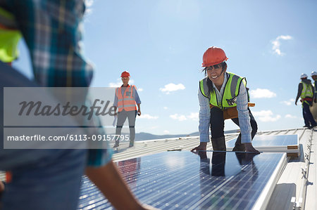 Engineers lifting solar panel at sunny power plant