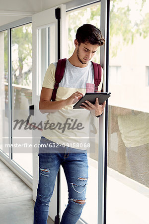 College student looking at digital tablet between classes