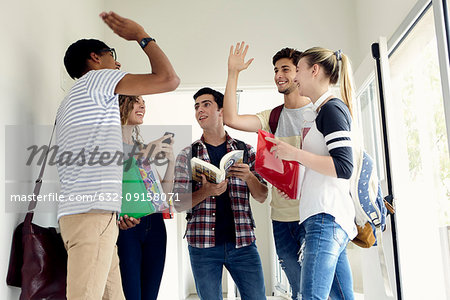 Students giving each other a high-five in corridor