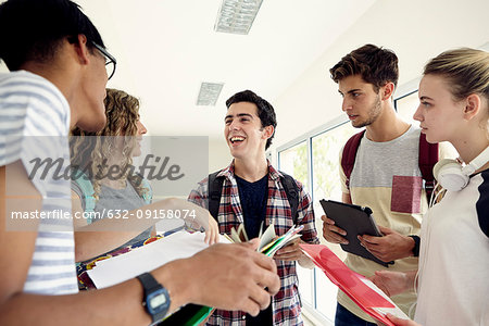 Group of students chatting together in school corridor