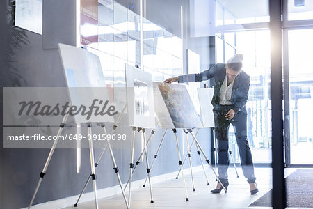 Businesswoman checking ideas boards in office