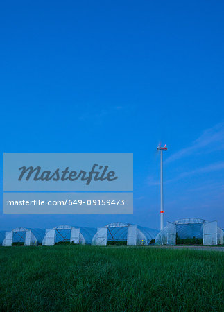 Greenhouses and spinning wind turbine at night, Hoogstraten, Antwerpen, Belgium