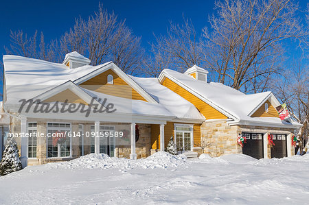 Natural cut stone with yellow wood cladding country style house facade in winter