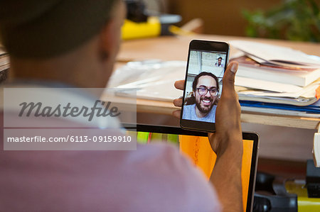 Businessman video chatting with colleague on smart phone