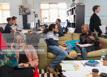 Creative business people meeting and working in casual, open plan office